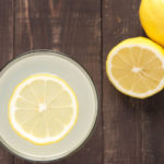 39100422 – top view lemonade with fresh lemon on wooden background.