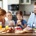 family mother father and children have Breakfast in kitchen in morning